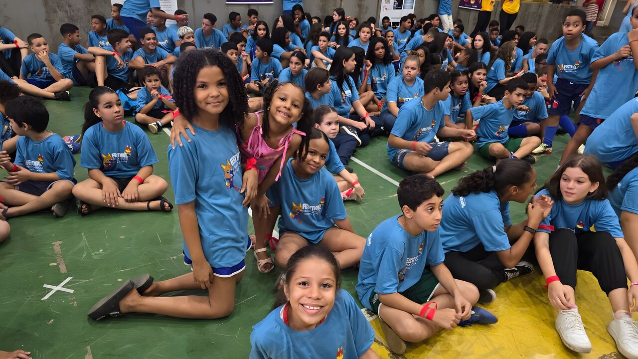 Crianças do Festival de 2024 com as camisetas azuis do projeto, sorrindo para a foto